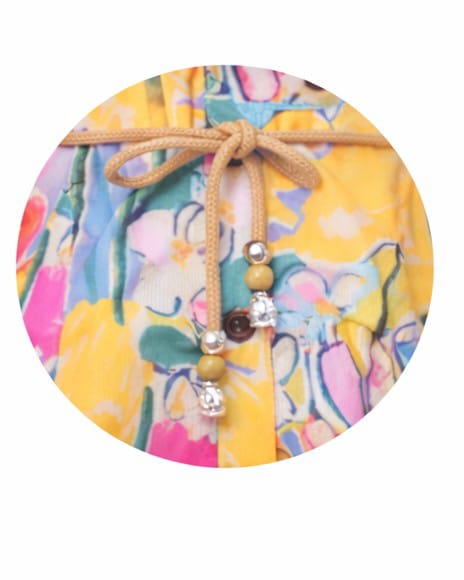 Colorful fabric with a floral pattern and a string with beads on a white background